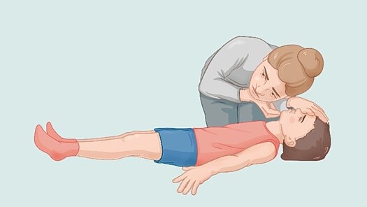 1. PRÜFEN! Eine Frau beugt sich über einen am Boden liegenden Jungen