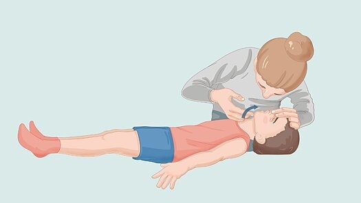 3. DRÜCKEN! Eine Frau macht eine Herz-Lungen-Massage bei einem auf dem Rücken liegenden Jungen