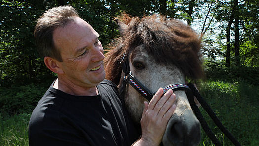 Stephan Maaß streichelt ein Pferd.