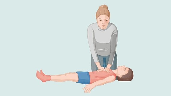 Frau macht Herzdruckmassage beim Kind